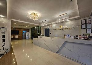 a lobby of a hotel with a counter and chandelier at THE TIMES HOTEL in Angeles