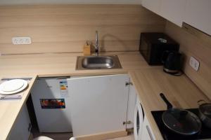 uma pequena cozinha com um lavatório e um pequeno frigorífico em Yes Апарт-отель em Astana