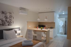 ein Schlafzimmer mit einem Bett und einem Schreibtisch sowie eine Küche in der Unterkunft Yes Апарт-отель in Astana