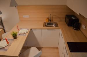 eine kleine Küche mit einer Spüle und einer Theke in der Unterkunft Yes Апарт-отель in Astana