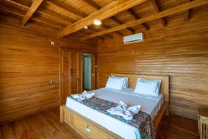 1 dormitorio con 1 cama con paredes de madera y suelo de madera en Butterfly Villas Nusa Ceningan, en Nusa Lembongan