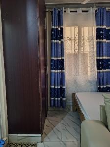 a small room with a bed and curtains at Jackie homes in Mombasa