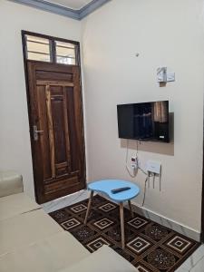 Cette chambre dispose d'une porte, d'une chaise et d'une télévision. dans l'établissement Jackie homes, à Mombasa