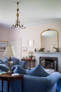 a living room with blue couches and a fireplace at Whitehouse Country House in Saint Boswells