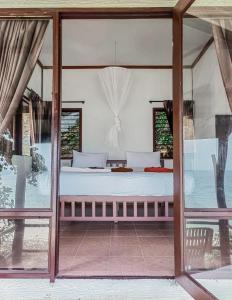 sypialnia z łóżkiem w pokoju ze szklanymi drzwiami w obiekcie Phi Phi Private Beach Resort w Ko Phi Phi