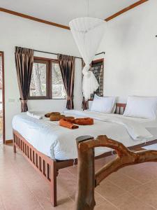 um quarto com uma cama grande e lençóis brancos em Phi Phi Private Beach Resort em Phi Phi Don