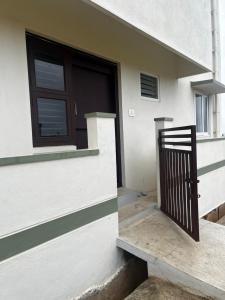 una puerta de una casa con porche y ventana en Shobha Comforts, en Chikmagalur