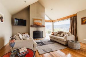 a living room with two couches and a fireplace at Chinamans Ridge on Chinamans Terrace - Bendigo, Tarras - Central Otago in Tarras