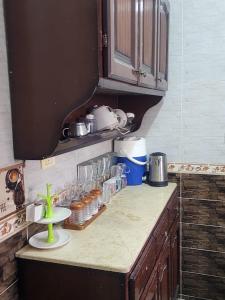 een keuken met een aanrecht met potten en een plank bij شقه الهاني in Marsa Matruh