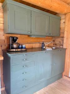 una cocina con armarios azules y fregadero en Stallen - koselig lite hus på gårdstun en Skjåk