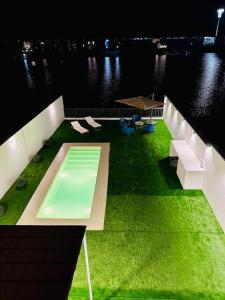 Ocean View Villa في الفجيرة: مقعد أبيض على سطح السفينة مع عشب أخضر