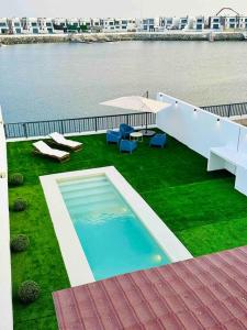 富查伊拉Ocean View Villa的享有水景的草坪上的游泳池