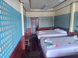 two beds in a room with blue walls at Friendship Guest House in Don Det