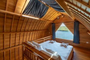 een kamer met een bed en een raam in een boot bij Butterfly Villas Nusa Ceningan in Nusa Lembongan
