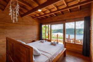 een slaapkamer met een bed en een groot raam bij Butterfly Villas Nusa Ceningan in Nusa Lembongan