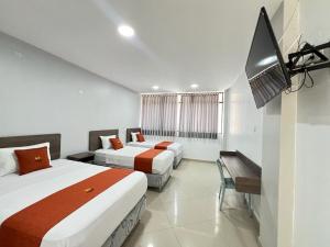a hotel room with two beds and a flat screen tv at HOTEL MAGIC in Piura