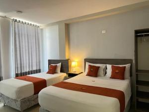 a hotel room with two beds and a window at HOTEL MAGIC in Piura