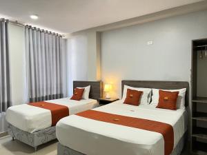 two beds in a hotel room with two bedsskirts at HOTEL MAGIC in Piura