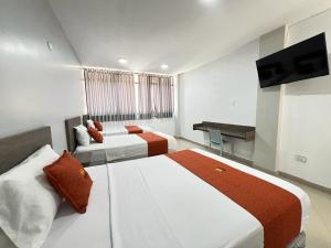 um quarto de hotel com duas camas e uma televisão em HOTEL MAGIC em Piura