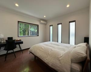 宇流麻的住宿－白礁公寓，卧室配有一张床、一张书桌和窗户。