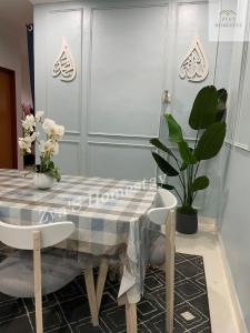 a dining room table with a checkered table cloth and plants at Zya'S Homestay Gong Badak in Kampong Bukit Berangan