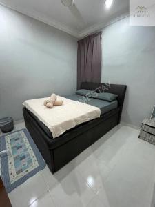 a bedroom with a bed with a towel on it at Zya'S Homestay Gong Badak in Kampong Bukit Berangan