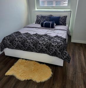a bedroom with a bed with a rug and a window at Aesthetic & classy apartment unit in Vaughan