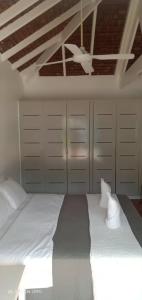 una habitación con una cama con sábanas blancas y armarios en Solwata House, On the Water Sleeps 6, en Port Vila