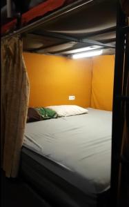 a bunk bed in a room with a yellow wall at Rubikz Hostel & Cafe in Surabaya