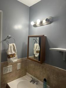 a bathroom with a sink and a mirror at Glamour Room C 6mins to Newark Liberty International Airport and 3mins to Near Penn Station in Newark