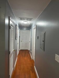 an empty hallway with white walls and wooden floors at Glamour Room C 6mins to Newark Liberty International Airport and 3mins to Near Penn Station in Newark