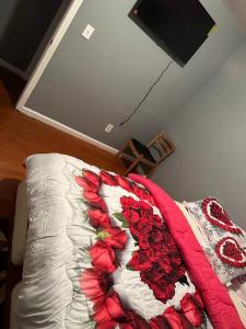 a bed with a blanket with roses on it at Glamour Room C 6mins to Newark Liberty International Airport and 3mins to Near Penn Station in Newark