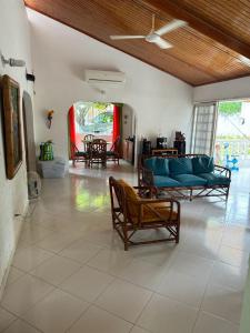 Una sala de estar con un sofá azul y sillas. en Casa quinta La herradura valle verde, en Melgar