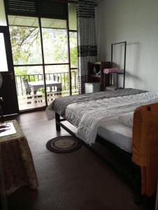 een slaapkamer met een groot bed en een balkon bij Chanidu Ella Inn in Ella