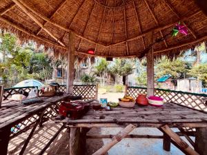 a picnic table in a straw umbrella with food on it at Satrangi Homestay Sundarban in Kākdwīp