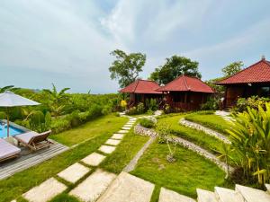 un jardín con piscina y un complejo en Sunset Hill Lembongan, en Nusa Lembongan