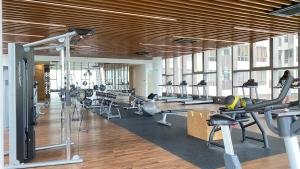 ein Fitnessstudio mit Laufbändern und darin trainierenden Menschen in der Unterkunft Bali Residence with Living Hall Melaka in Malakka