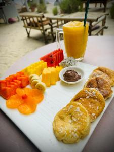 un piatto di cibo con frutta, verdura e una bevanda di SeaEsta Beach a Baan Tai