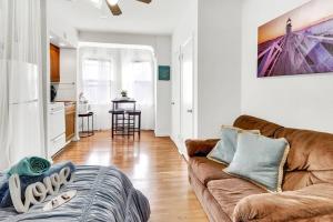 a living room with a brown couch and a kitchen at Private Remodeled Studio In Vibrant Center City in Philadelphia