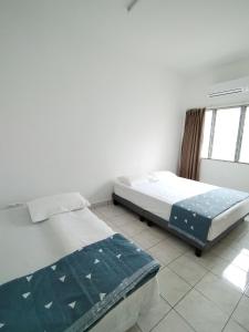 um quarto com 2 camas e uma janela em Wong Bentong Makmur Homestay em Bentong