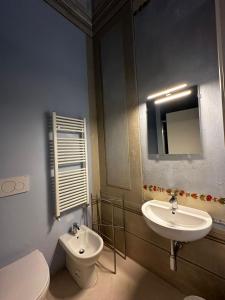 a bathroom with a sink and a toilet and a mirror at The Street River in Pisa