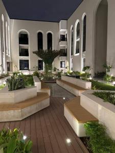 um pátio com bancos e plantas num edifício em شقة مودرن 3غرف نوم وصاله بالملقا c em Riade