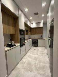 a large kitchen with white cabinets and appliances at شقة مودرن 3غرف نوم وصاله بالملقا c in Riyadh