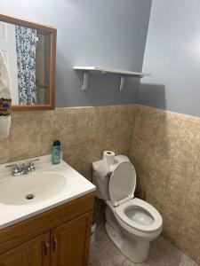 y baño con aseo y lavamanos. en Divine GUEST HOUSE Room B 6MINS TO NEAR Newark Liberty International Airport AND 4 MINS To Penn Station Prudential, en Newark