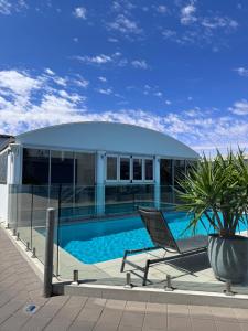 uma casa com uma piscina e uma cadeira em ibis Styles Broken Hill em Broken Hill
