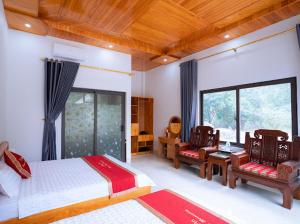 - une chambre avec un lit et deux chaises dans l'établissement Trang An Nature View Homestay, à Nguyên Ngoại