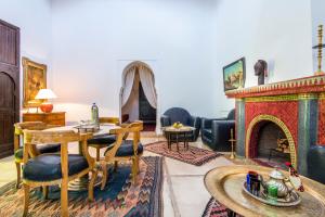 a living room with a table and a fireplace at Riad dar Ourika in Marrakesh