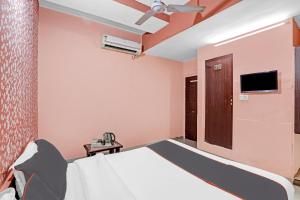 - une chambre avec un lit et un ventilateur de plafond dans l'établissement Collection O Hotel Raj Palace, à Sātej