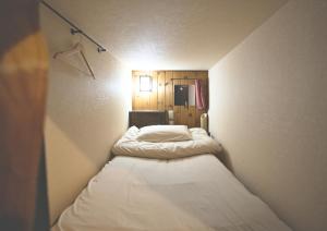 um pequeno quarto com duas camas em Hostel Knot em Izu