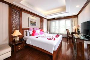 a bedroom with a large bed with pink balloons on it at Thien Thai Hotel & Spa in Hanoi